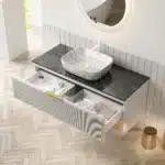 Bathroom vanity with sink and floating cabinet in a bright bathroom, pinstripe drawers and plywood finish visible.