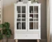 Modern white sideboard cabinet with double glass doors and drawer in a living room