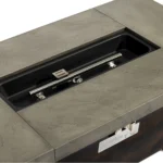 Modern metal propane fire pit on patio with glowing flames