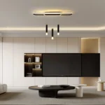 Three-light acrylic pendant light in black, dimmed to a warm glow, illuminating a kitchen counter.