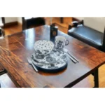Elegant floral dinnerware set with gray and ivory ceramic plates and bowls arranged on a wooden table