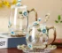 Elegant crystal glass tea mug with enamel floral design and handgrip on a wooden table