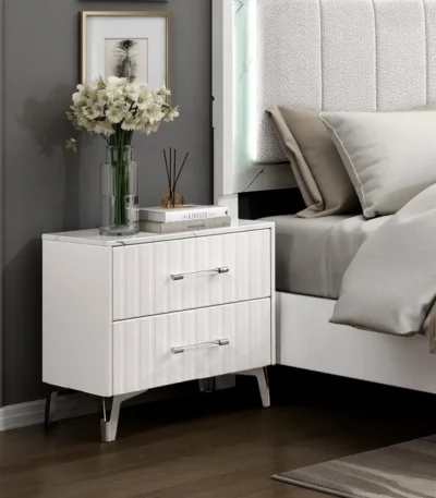 White two-drawer nightstand with faux marble top and chrome legs in a modern bedroom setting