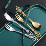 24-piece stainless steel cutlery set with gold handles displayed on a wooden table