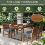 Modern acacia wood dining set with four chairs and adjustable legs on a backyard patio