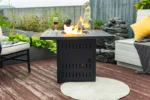 Modern outdoor gas fire pit column with blue flames on a stone patio