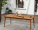 Modern acacia wood dining table with six chairs on a patio