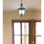 Close-up of HMS Belle matte black hanging light with adjustable beam switch and E26 base bulbs.