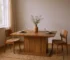 Brown wood extendable dining table with self-storing leaf and pedestal base in a modern dining room