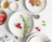 Set of retro dinner plates with white petal design on a wooden table