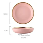 Elegant dinnerware set with gilt rim pink porcelain plates, bowls, mugs, and cutlery on a table