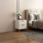 Modern nightstand with drawers, gold legs, and 3D embossed design in a bedroom setting