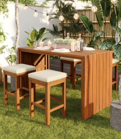 Modern outdoor bar set with acacia wood table and four cushioned stools on a patio