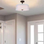 The semi flush mount ceiling light installed in a living room with natural light from a window.
