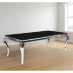 Black and white glass dining table with stainless steel base in modern home