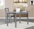 Dark gray extendable dining table extended to seat eight, with chairs in a modern dining room
