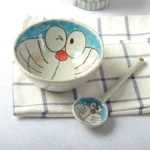 Japanese ceramic dinnerware set with hand-drawn cat design on blue rectangular plate and bowl