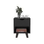 Modern nightstand with drawer and open shelf in black finish with wooden legs on a bedroom floor next to a bed