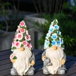 Close-up of resin garden gnome with solar panel on hat, textured white finish.