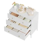 Modern white 3 drawer dresser with gold-tone knobs and lacquer finish in a bedroom setting