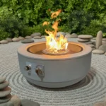 Galvanized steel outdoor fire pit with natural gas flame on a patio