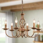 Rustic farmhouse chandelier with six lights in bronze iron, hanging over a wooden dining table with chairs in a cozy