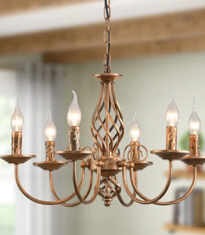 Rustic farmhouse chandelier with six lights in bronze iron, hanging over a wooden dining table with chairs in a cozy