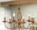 Rustic farmhouse chandelier with six lights in bronze iron, hanging over a wooden dining table with chairs in a cozy