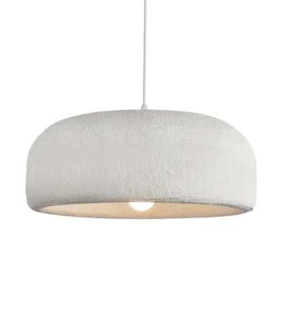 Nordic minimalist wabi-sabi wind LED pendant light with warm glow over a wooden dining table in a cozy restaurant