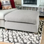 Goldoma light gray fabric cocktail ottoman with brown wood frame in living room