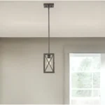 Close-up of bronze geometric mini pendant light showing intricate metal frame and bulb inside.