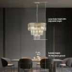 Side view of the 20-inch pendant light with gold finish and cascading crystals, suspended over a cozy seating area.