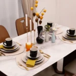 Elegant dinnerware set with white minimalist plates arranged on a wooden table