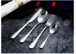 Elegant gold flatware set with fork, knife, and spoon on a white tablecloth