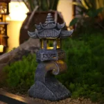 Solar pagoda lantern garden statue with warm glow at dusk, placed on stone path.