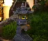Solar zen garden lantern pagoda statue glowing in a garden at dusk