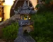 Solar zen garden lantern pagoda statue glowing in a garden at dusk