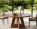 Round marble dining table with wood legs in a modern dining room setting