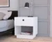 White small bedroom nightstand with one drawer and open shelf next to a bed