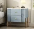 Modern fluted nightstand with drawers featuring golden metal handles and legs in a bedroom setting