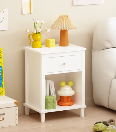 White wooden nightstand with one drawer and one shelf, 26.77 inches tall, placed beside a bed