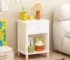 White nightstand with drawer and shelf in a modern bedroom setting