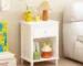 White nightstand with drawer and shelf in a modern bedroom setting