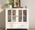 Vintage china cabinet with double-glazed doors and brass bell handles in a dining room
