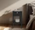 Modern black bedside table with one drawer and open shelf in a bedroom setting