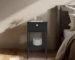 Modern black bedside table with one drawer and open shelf in a bedroom setting