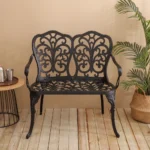 Outdoor metal bench with floral rose design in black finish on a patio