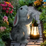 Two solar rabbit statues facing each other on a lawn, one in brown and one in white.