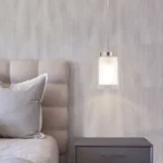 Mini pendant light illuminating a kitchen island, with dual glass shades and adjustable cord lengths.
