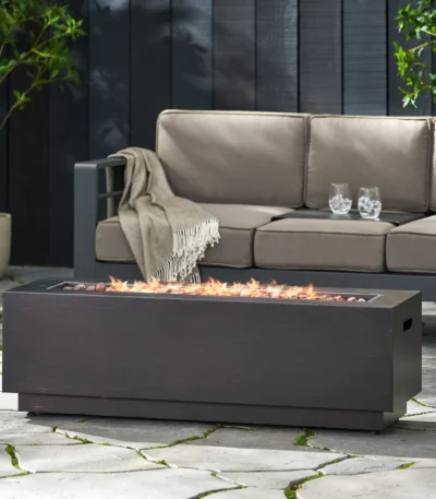 Outdoor propane fire pit in dark grey rectangular iron with glowing flames